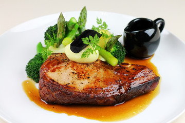 Beef steak with steamed vegetables close up.