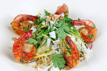 Shrimp and rice noodle salad with coconut chips, peanuts and coriander.