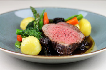Beef steak with steamed vegetables close up.