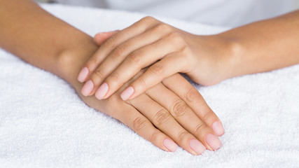 Fototapeta na wymiar Nude manicure. Female hands on white towel