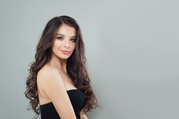 Fototapeta premium Cheerful model brunette, portrait. Pretty woman with long healthy curly hairstyle on banner background