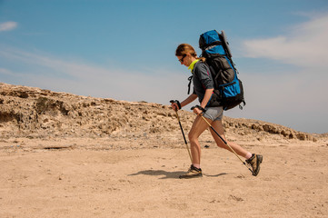 Young female wanderer travels in a desert