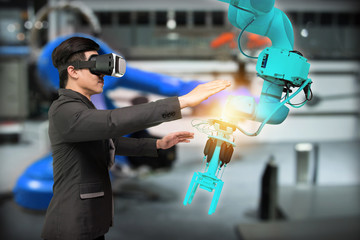 Virtual reality technology in industry 4.0. Business man suit wearing VR glasses to see AR service , Thermal Monitoring motor for check destroy part of smart robot arm machine in smart factory.