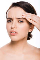 Obraz premium sad young woman touching face and looking at camera isolated on white