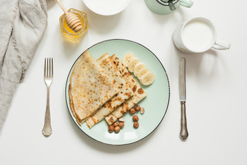 Tasty traditional russian breakfast pancakes, milk, sour cream, honey. Springtime. Shrovetide.