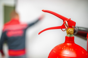 Uniformed fireman gives a lecture or instruction on fire safety. The instructor teaches the use of...