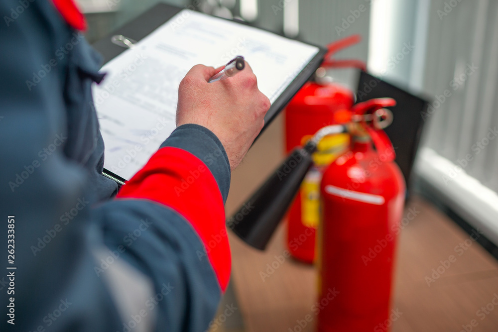 Wall mural engineer professional are checking a fire extinguisher using clipboard or checking industrial fire c