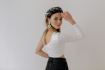Attractive stylish blond woman wearing top, shawl and jewelry posing at camera over isolated background 