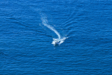 Aerial view of motor boat cruising through calm sea waters .