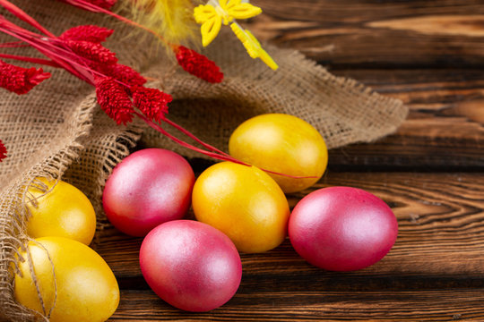 Easter eggs on a sackcloth and wooden background. Happy easter Bright multicolored shiny easter eggs. Background with easter eggs.