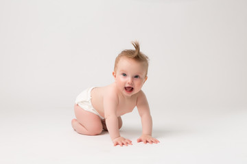baby girl 6 months in diapers on white isolate background,6 months old baby girl, crawling happy...