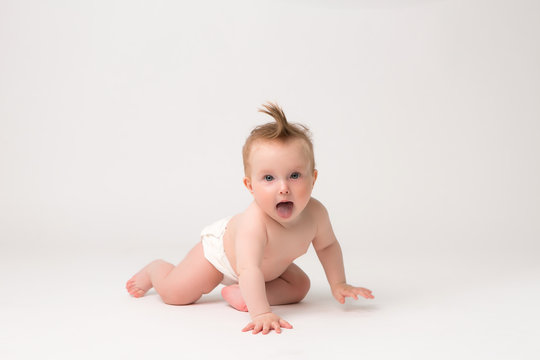 baby girl 6 months in diapers on white isolate background,6 months old baby girl, crawling happy smiling on a white background