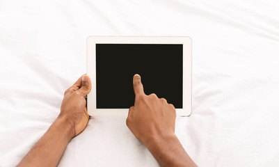 Modern big digital tablet with blank screen in bed