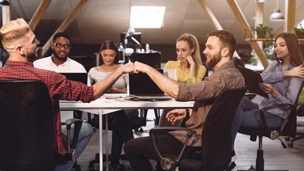 Fist bump. Colleagues celebrating successful teamwork in office