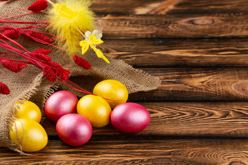Easter eggs on a sackcloth and wooden background. Happy easter Bright multicolored shiny easter eggs. Background with easter eggs.