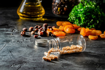 Vitamins, dietary supplements, drugs, tablets pils and capsules on dark background with a medical bottle