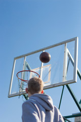 a young man in a gray jacket playing basketball