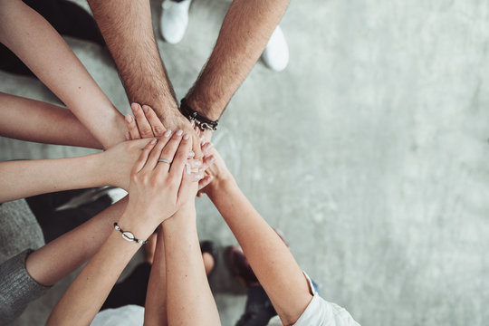 Teamwork, unity concept, group of friends put their hands together with copy space