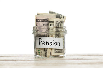 Us dollar money for pension in glass jar on wooden table on white background