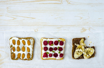 Healthy breakfast toasts with peanut butter, banana, chocolate, chia seeds, raspberries, almond, yogurt, oranges, grapefruit. Copy space