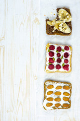 Healthy breakfast toasts with peanut butter, banana, chocolate, chia seeds, raspberries, almond, yogurt, oranges, grapefruit. Copy space