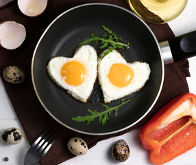 Fried eggs in the form of a heart in a skillet