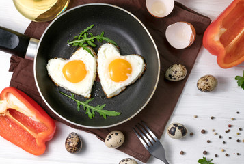 Fried eggs in the form of a heart in a skillet