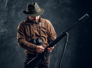 Opening of the spring hunting season. Hunter ready to hunt and charging a hunting rifle. Studio...