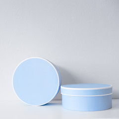 Blue round boxes on white table and white background like an objects of interior, gifts or packages
