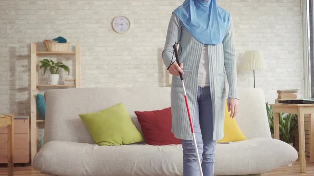 portrait of beautiful blind Muslim girl with a cane in hijab going for a walk