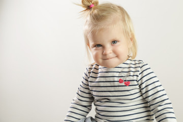 Studio portrait of adorable blonde smiling baby girl