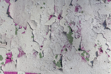 Beautiful horizontal texture of part of shabby old concrete wall painted in white and pink and green blue color with holes on the photo