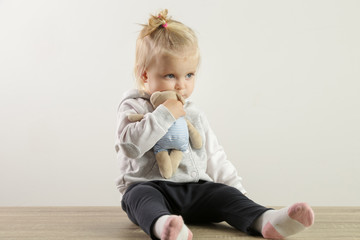 Naklejka premium An adorable baby girl hugging with her favorite soft toy