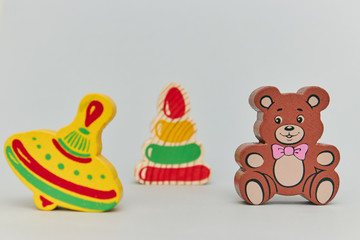 Background of children's colorful wooden toy figures for children on a light background. vertical view close-up.