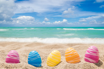 Happy easter lettering background with eggs on the sandy beach