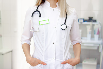 Medical staff working at the hospital: cropped woman doctor in white uniform. Mockup for doctor name. healthcare and medical exams concep