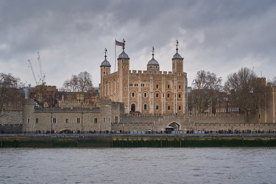 Cityscape Picture of Tower of London and Thames river during cloudy and windy day, british gothic castle, fortress and prison in London city from tudor age with treasury of royal crown and jewels.