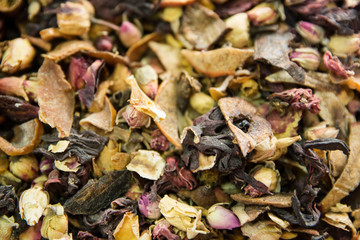 Oriental tea with blossoms like pink rose and pieces of fruits. Close up. 