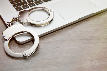 HANDCUFFS ON COMPUTER KEYBOARD