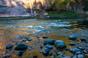 beautiful golden sunrise over forest river with sandstone cliffs on the shores