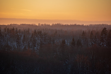 colorful sunset light over fields of snow in winter