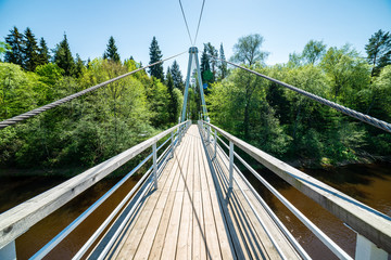 foot bridge over forest river in summer