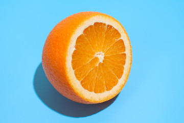 Ripe juicy delicious orange on blue background. Healthy eating and dieting concept