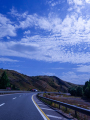 Empty asphalt road to the background blue sky