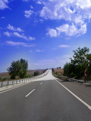 Empty asphalt road to the background blue sky