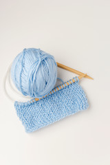 Set of wool yarns, crochet, knitting needles, in blue color on white background.