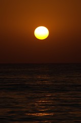 Sunset with large yellow sun under the sea surface