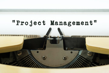 Project Management word typed on a yellow vintage typewriter. Business concept.