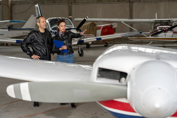 Student Pilot and Instructor Check an Aircraft for Safety in a Hangar