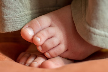 Happy child posing in room. Feet baby closeup. Little plump fingers.